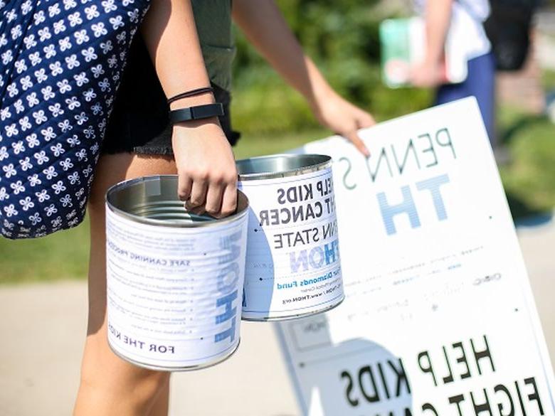 students holding dance marathon cans